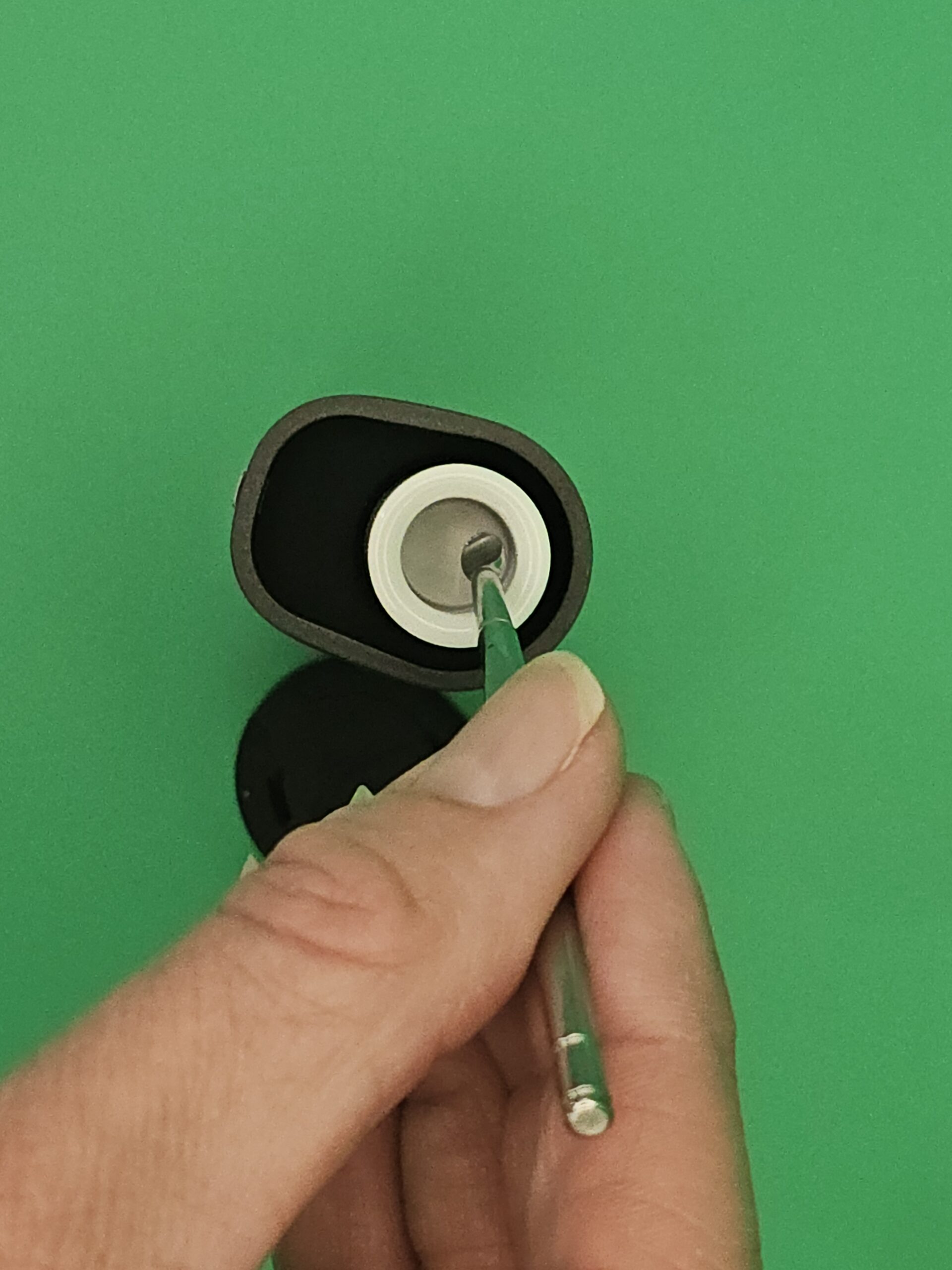 Hand holding the Yocan Pocket smart vaporizer open to show the chamber.